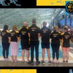 Waverley Swim Club team members with backs to the camera to show AWS Legal logo and team name